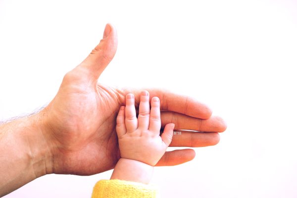 infant baby hand in father's hand, parent responsibility theme