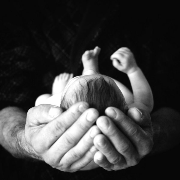 newborn baby in parent's hands, circumcision