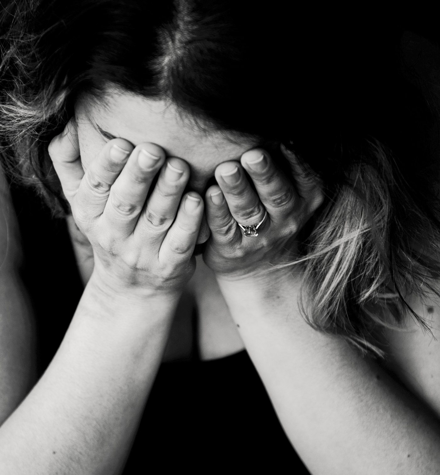 woman holding hands over face in grief