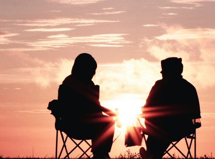 two people sitting talking outdoors