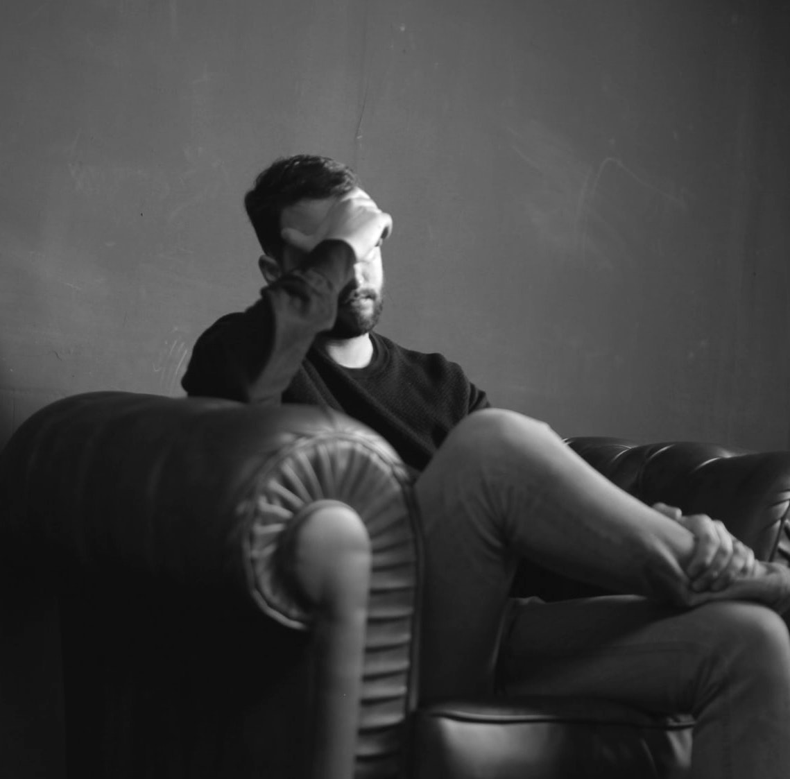 man thinking sad thoughts on couch