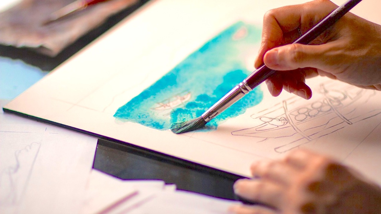 hands holding a paintbrush watercolor, art therapy