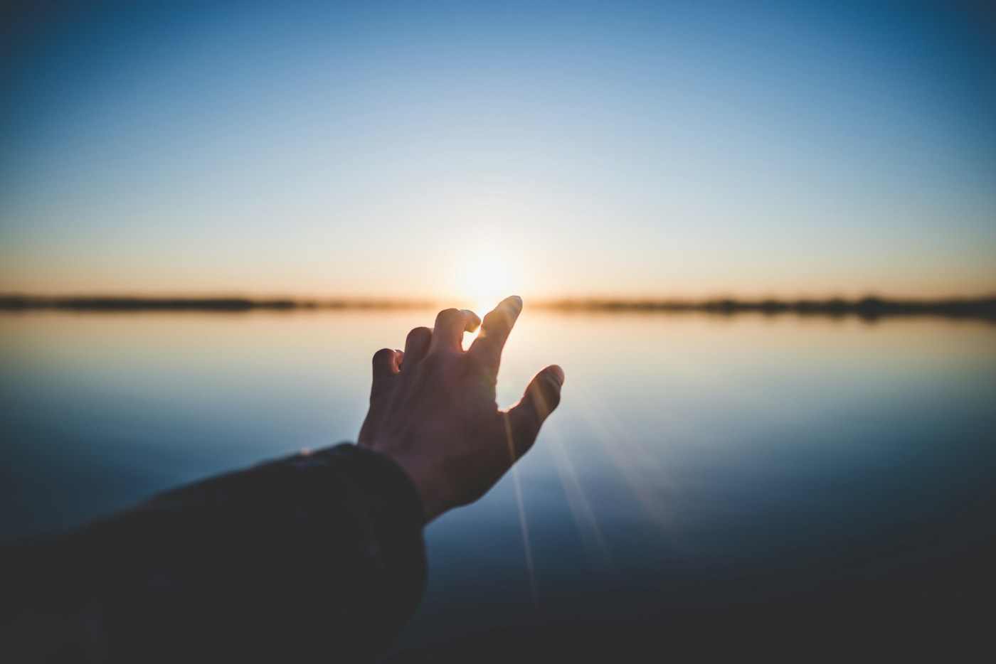 hand reaching out to sunrise hope