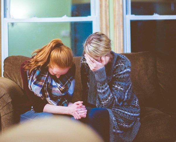 two people sitting and crying. I Lost a Child. What Do I Say to Another Grieving Parent?
