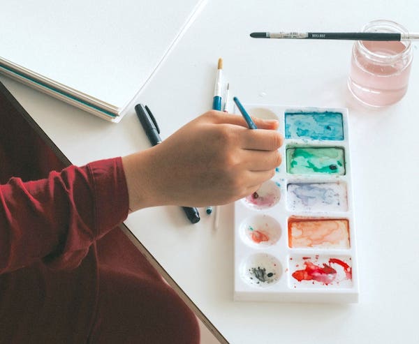 person painting with watercolors. art therapy for grief, keeping a child's memory alive