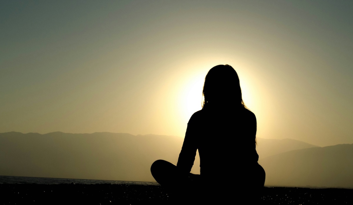 woman sitting peacefully in nature. taking a break from grief of child loss